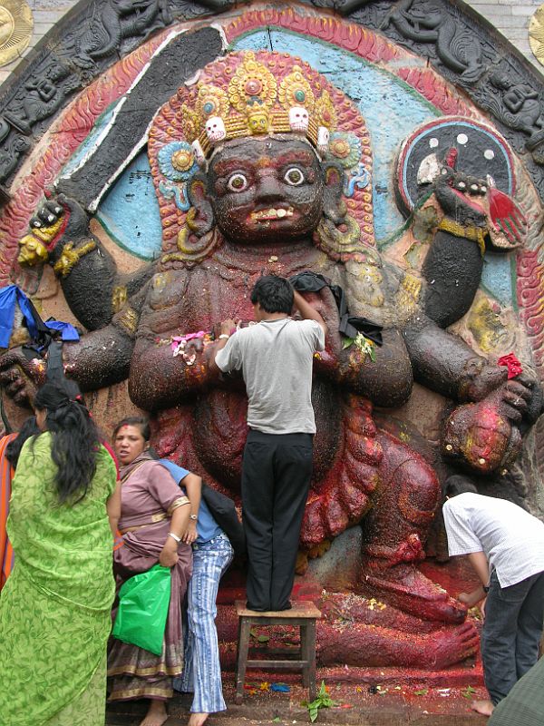 Kathmandu Durbar Square 05 04 Kala Bhairav Statue Hindu pilgrims touch the huge stone statue of Kala (black) Bhairav, Shiva's 6-armed destructive form, in Kathmandu Durbar Square. Atop his wide-eyed face is a crown decorated with human skulls, and on his back is a human skin. Kala Bhairav stands on a prostrate figure that represents human ignorance.